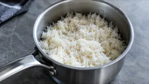 Riz blanc cuit aux grains détachés dans une casserole en inox