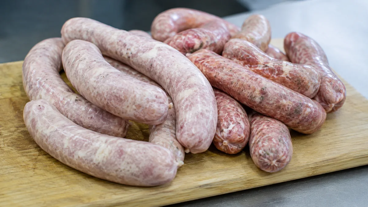Saucisses fraîches crues posées sur une planche à découper